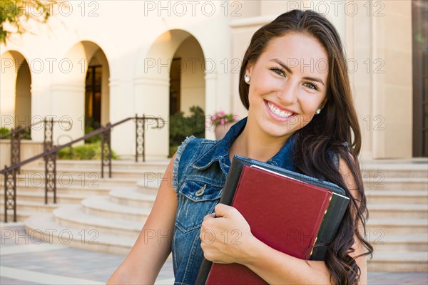 mixed-race young girl student with school books on campus