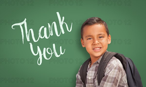 Cute hispanic boy in front of chalk board with thank you written on it