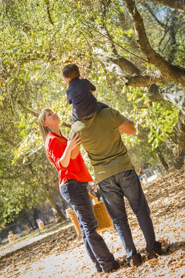 Happy mixed-race family with picnic basket enjoy a walk in the park