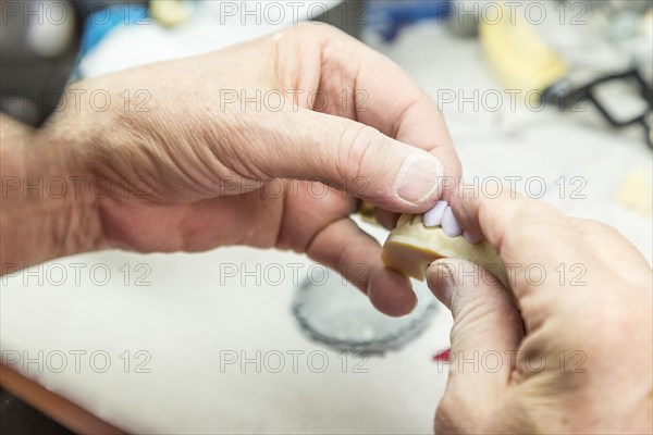 Male dental technician working on A 3D printed mold for tooth implants in the lab