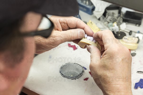 Male dental technician working on A 3D printed mold for tooth implants in the lab