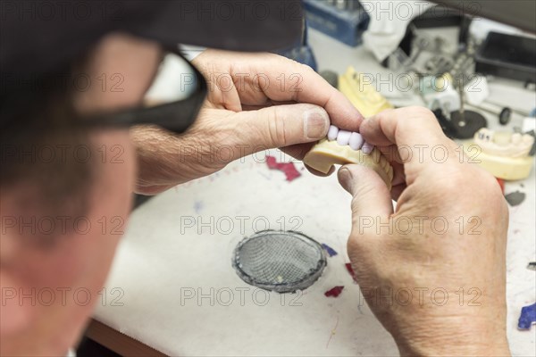 Male dental technician working on A 3D printed mold for tooth implants in the lab