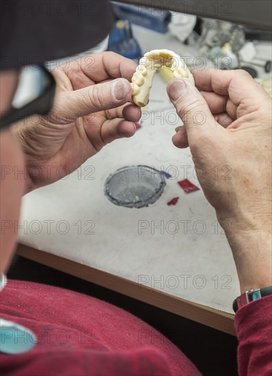 Male dental technician working on A 3D printed mold for tooth implants in the lab