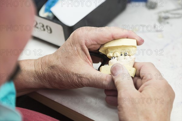 Male dental technician working on A 3D printed mold for tooth implants in the lab