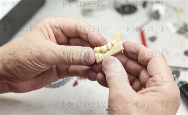 Male dental technician working on A 3D printed mold for tooth implants in the lab