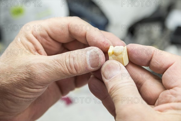 Male dental technician working on A 3D printed mold for tooth implants in the lab