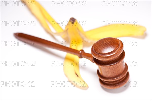Gavel and banana peel on gradated background with selective focus