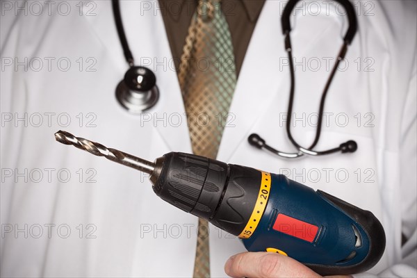 Doctor with stethoscope holding A very big drill