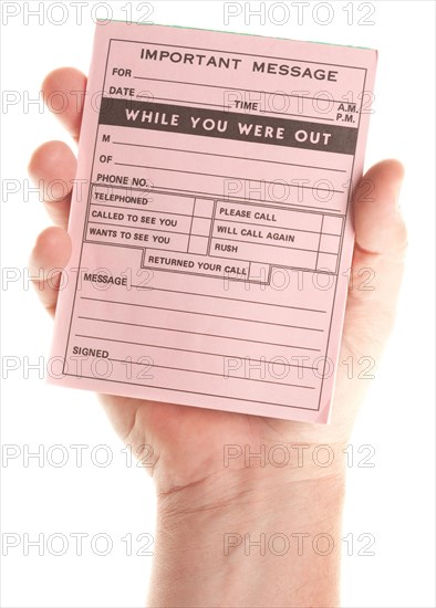 Male hand holding blank pink message pad isolated on a white background