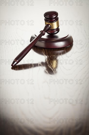 Dark wooden gavel abstract on reflective table with room for text