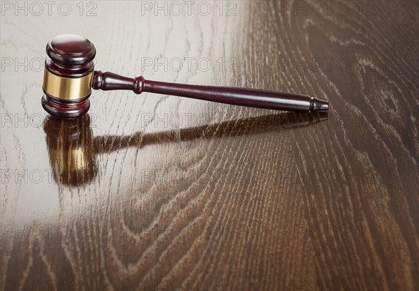 Dark wooden gavel abstract on reflective table with room for text