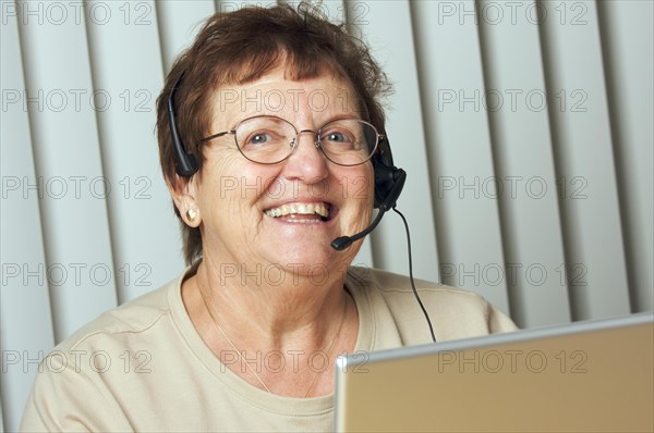 Smiling senior adult with telephone headset