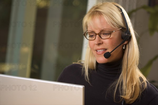 Attractive businesswoman talks on her phone headset