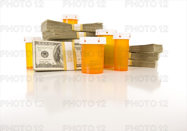 Empty medicine bottles and stacks of hundreds of dollars on reflective surface