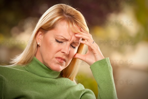 Grimacing woman suffering a painful headache or sorrow