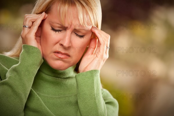 Grimacing woman suffering a painful headache