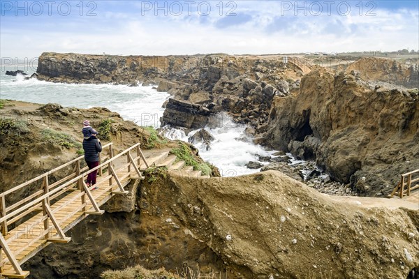 Father and little son admiring Papoa islet in Peniche