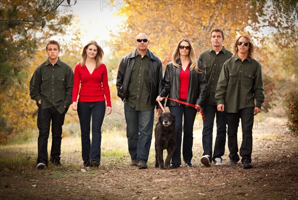 Attractive family portrait walking outdoors with their dog