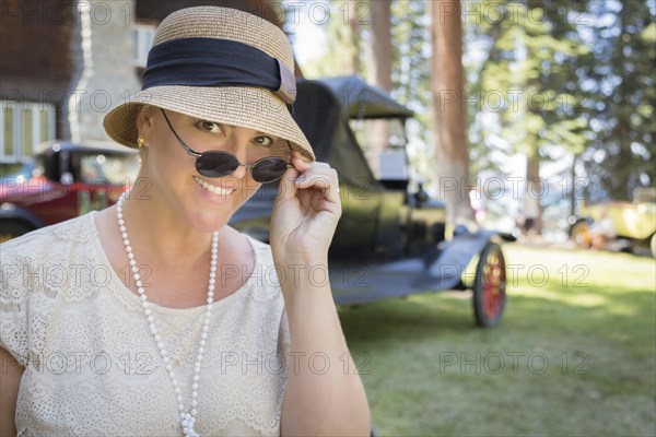 Beautiful 1920s dressed girl near vintage car outdoors portrait