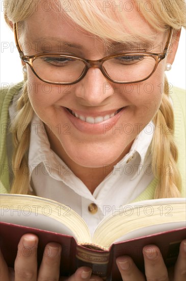 Female with ponytails reads her book isolated on a white background