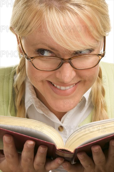 Female with ponytails reads her book isolated on a white background