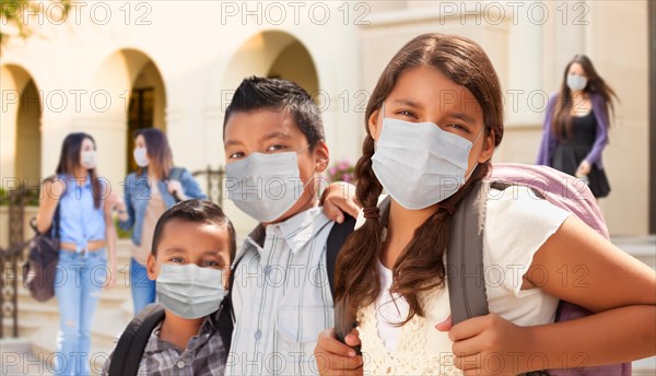 Young students on school campus wearing medical face masks