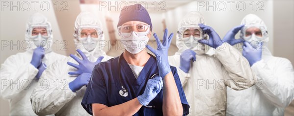 Team of female and male doctors or nurses wearing personal protective equiment in hospital hallway