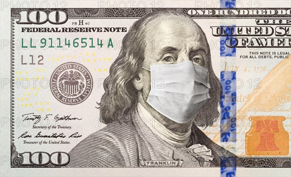 One hundred dollar bill with medical face mask on face of benjamin franklin