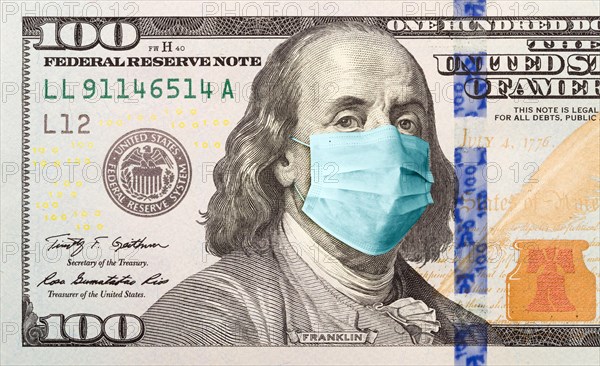 One hundred dollar bill with medical face mask on benjamin franklin