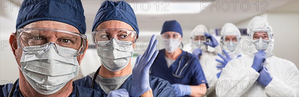 Team of female and male doctors or nurses wearing personal protective equiment in hospital hallway