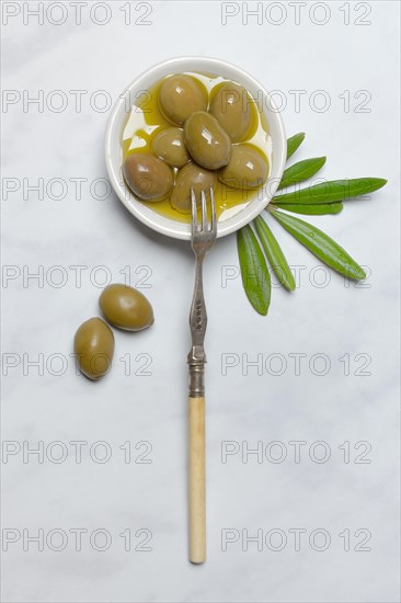 Green olives in small bowl with fork