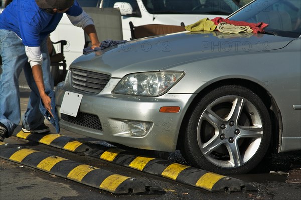 Abstract of car wash worker drying off luxury car