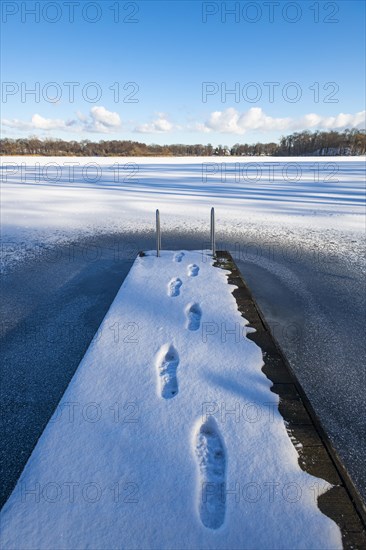 Footprints on jetty in snow