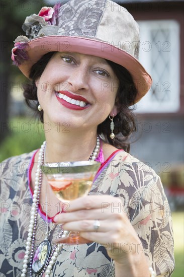 Beautiful 1920s dressed girl with glass of wine portrait