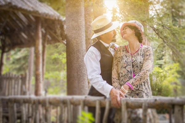 Attractive 1920s dressed romantic couple on wooden bridge