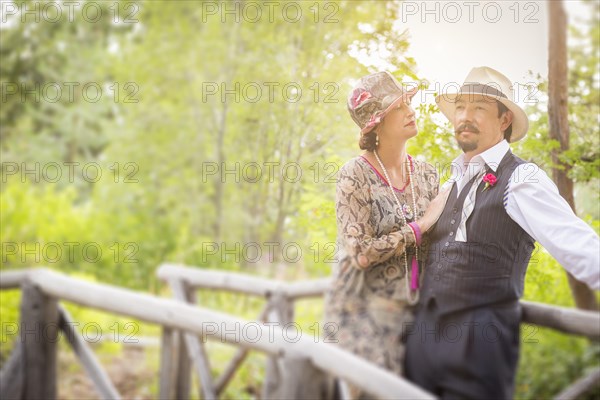 Attractive 1920s dressed romantic couple on wooden bridge