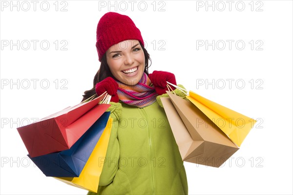 Beautiful mixed-race woman wearing winter hat and gloves isolated on a white background looking to the side
