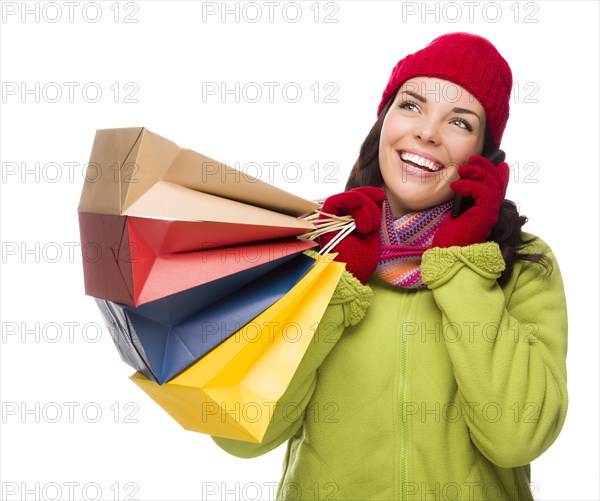 mixed-race woman holding shopping bags talking on cell phone looking up and to the side isolated on white background