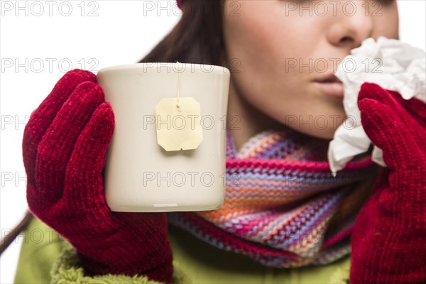 Young sick woman with tissue holding cup with blank tea bag hanging