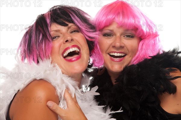 Portrait of two pink and black haired smiling girls with boas isolated on a white background