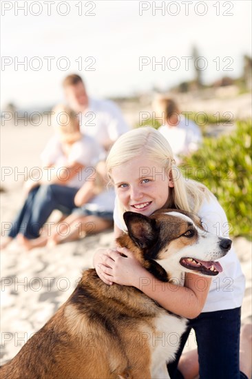 Cute girl playing with her dog at the beach