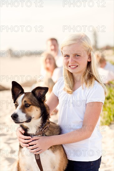 Cute girl playing with her dog at the beach