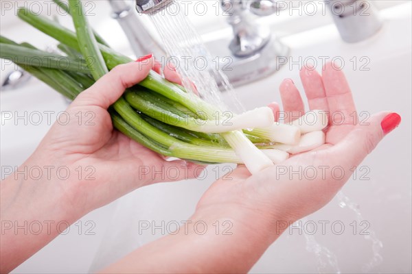 Woman washing onions in the kitchen sink