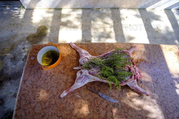 Whole lamb marinating in oil rub and rosemary for asado