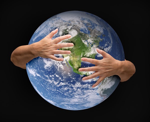 Human arms embracing and nurturing the planet earth