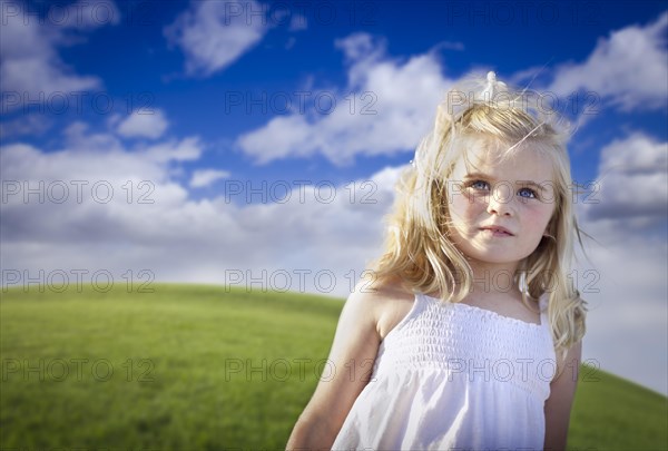 Adorable blue eyed girl playing outside in the grass field