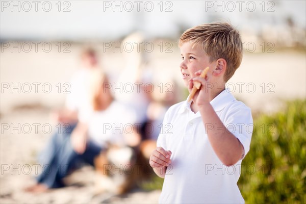 Cute little blonde boy showing off his starfish at the beach