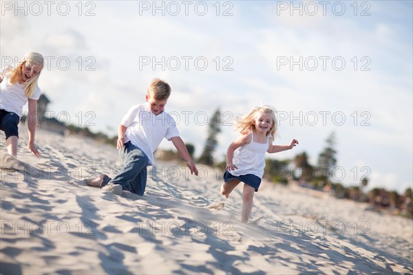 Adorable brother and sisters having fun at the beach one afternoon