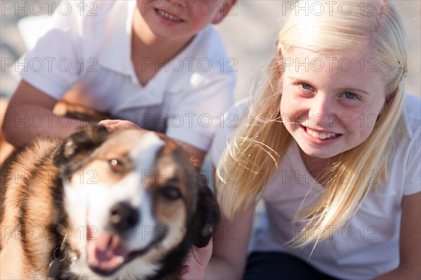 Cute girl playing with her dog at the beach