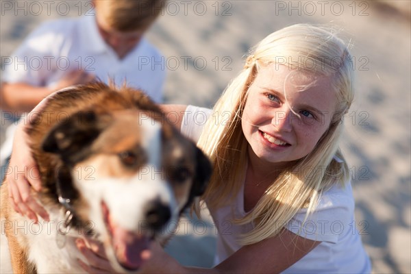 Cute girl playing with her dog at the beach